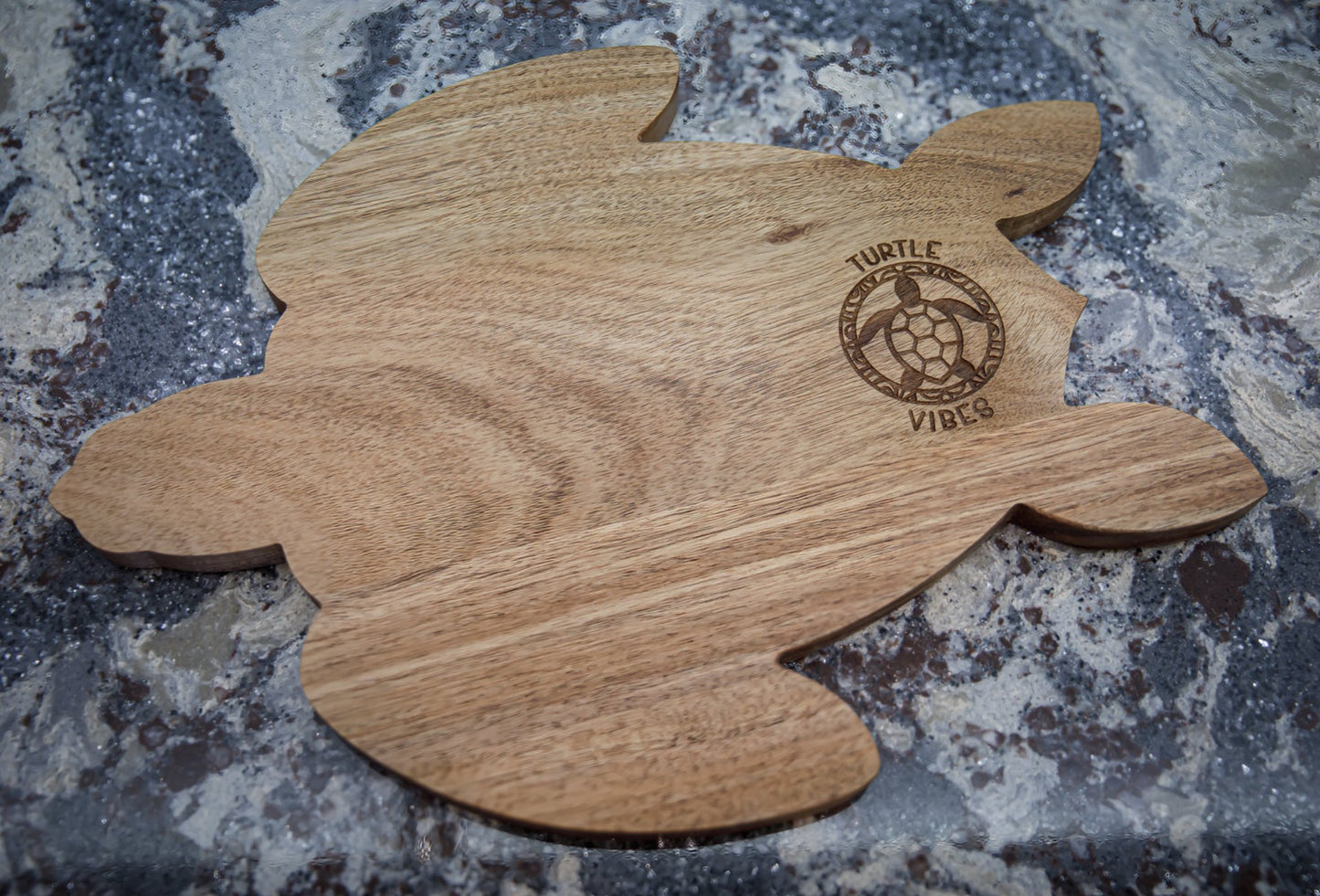 Photo of an acacia wood charcuterie board in the shape of a turtle.