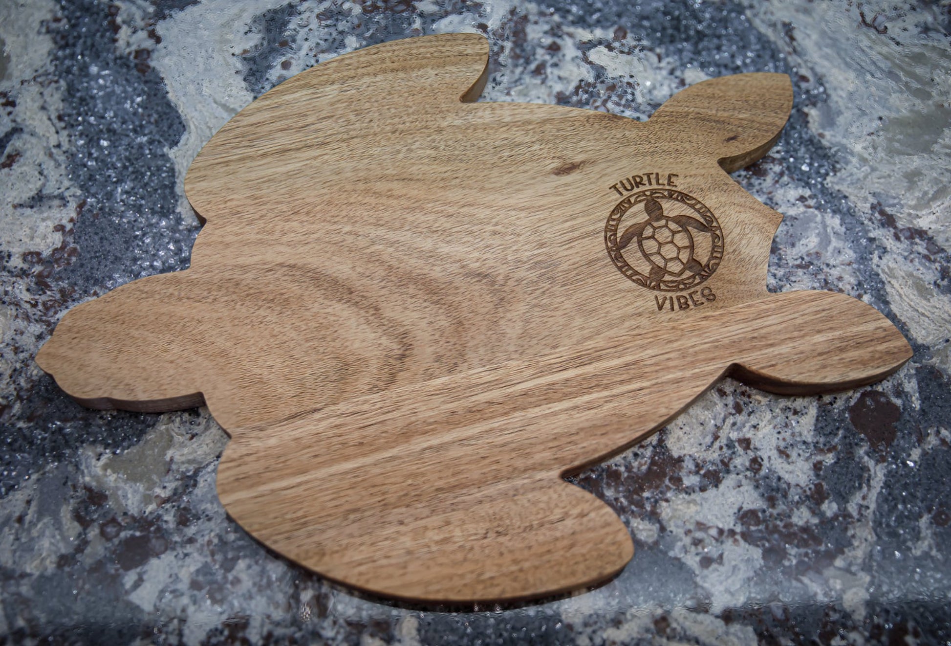 Photo of an acacia wood charcuterie board in the shape of a turtle.