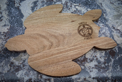 Photo of an acacia wood charcuterie board in the shape of a turtle.